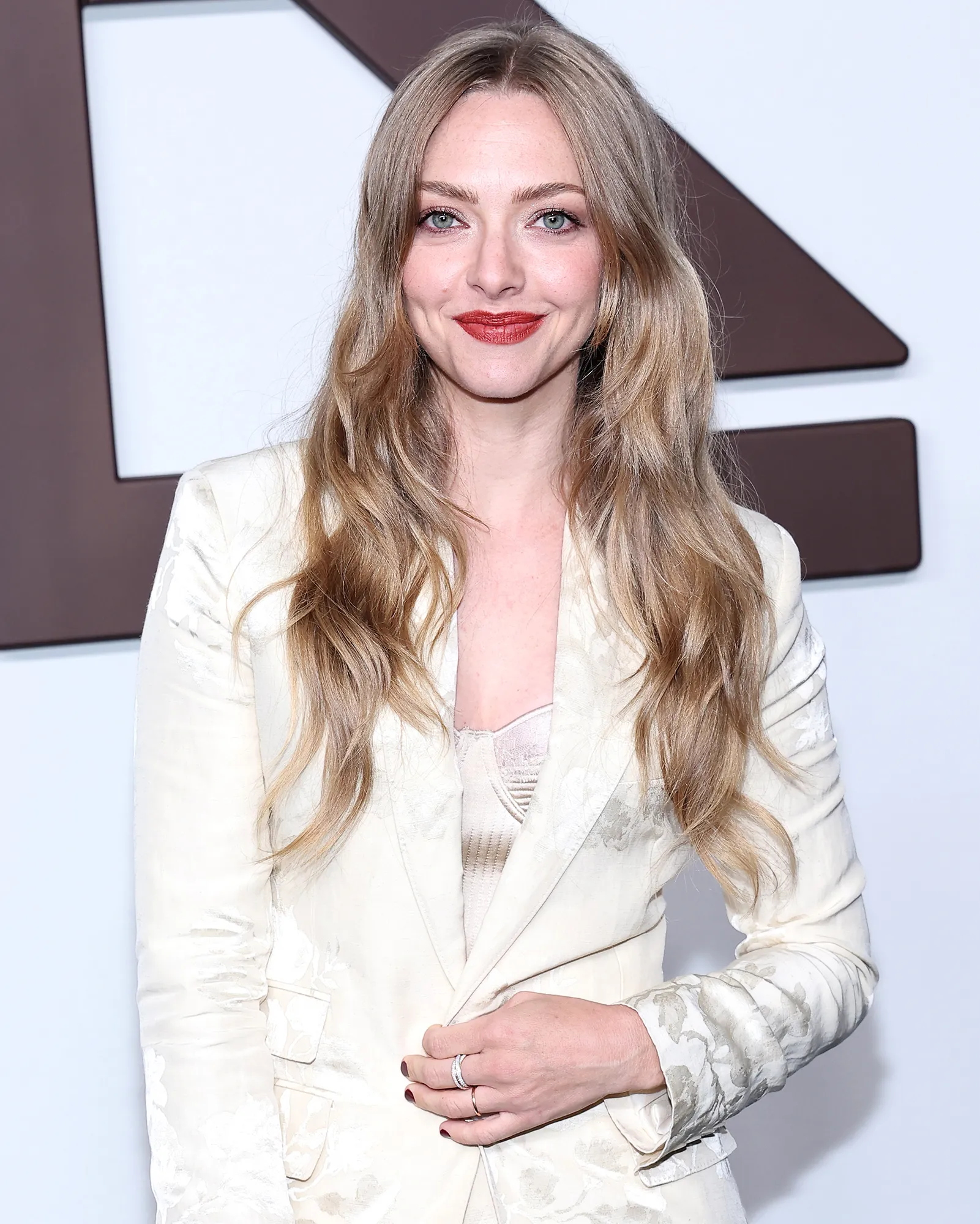 Amanda Seyfried Looking at camera Smiling wearing cream colored blazer and matching top