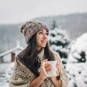 Young woman enjoying the snowy winter day with a cup of hot tea