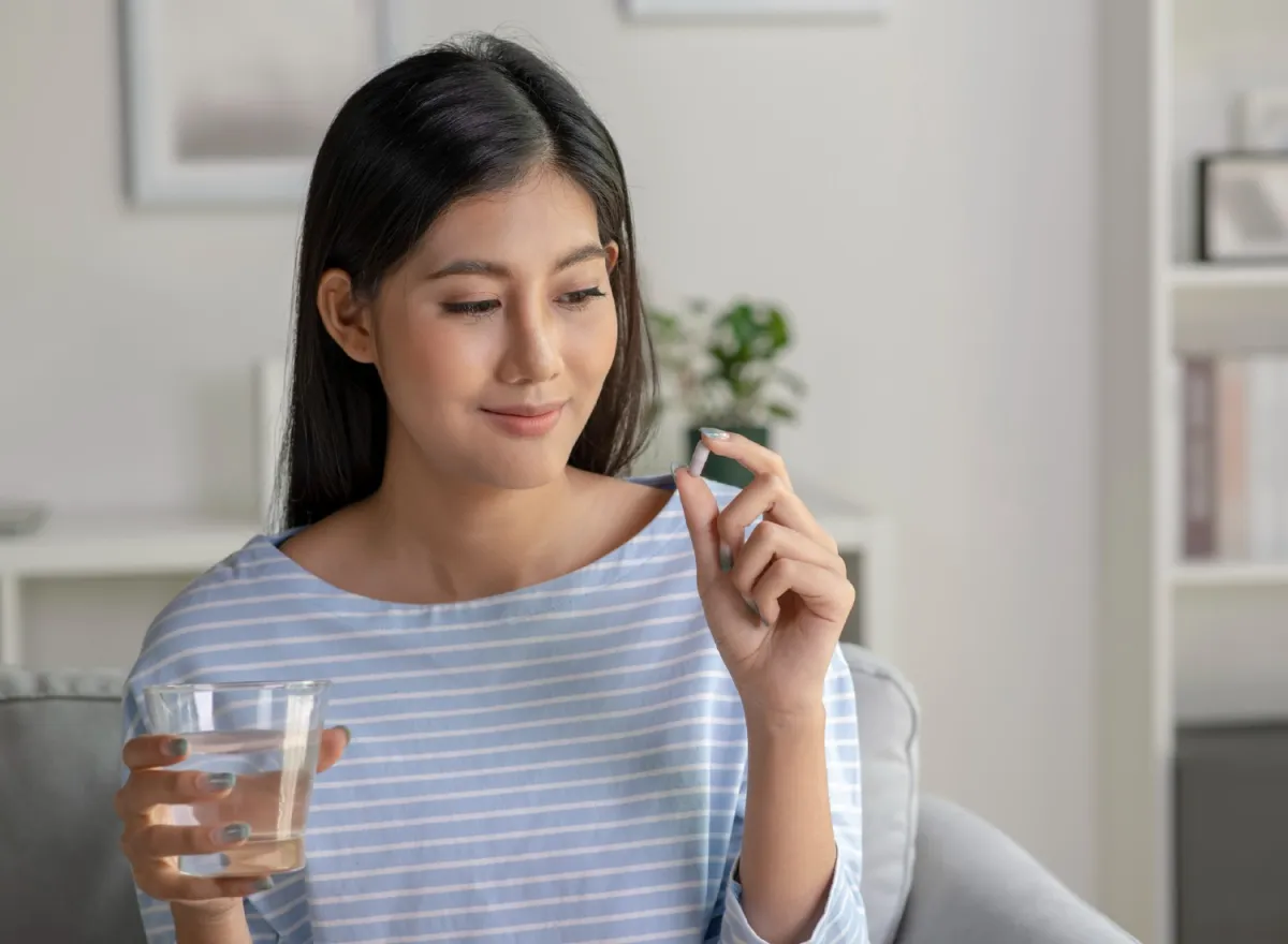 Woman preparing to take a supplement