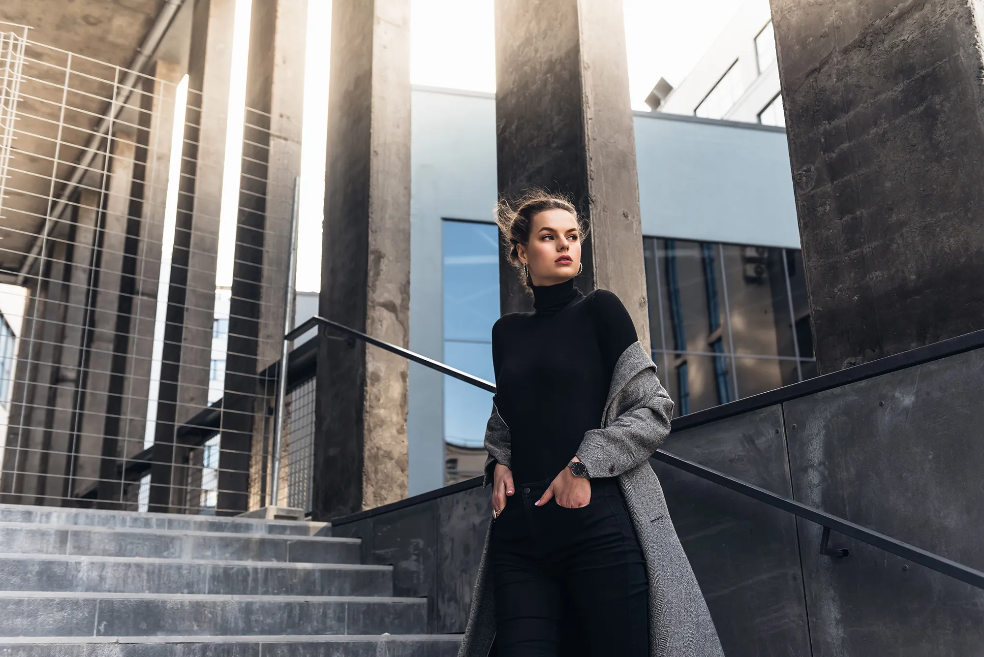 Young elegant woman in the street dressed with a grey coat