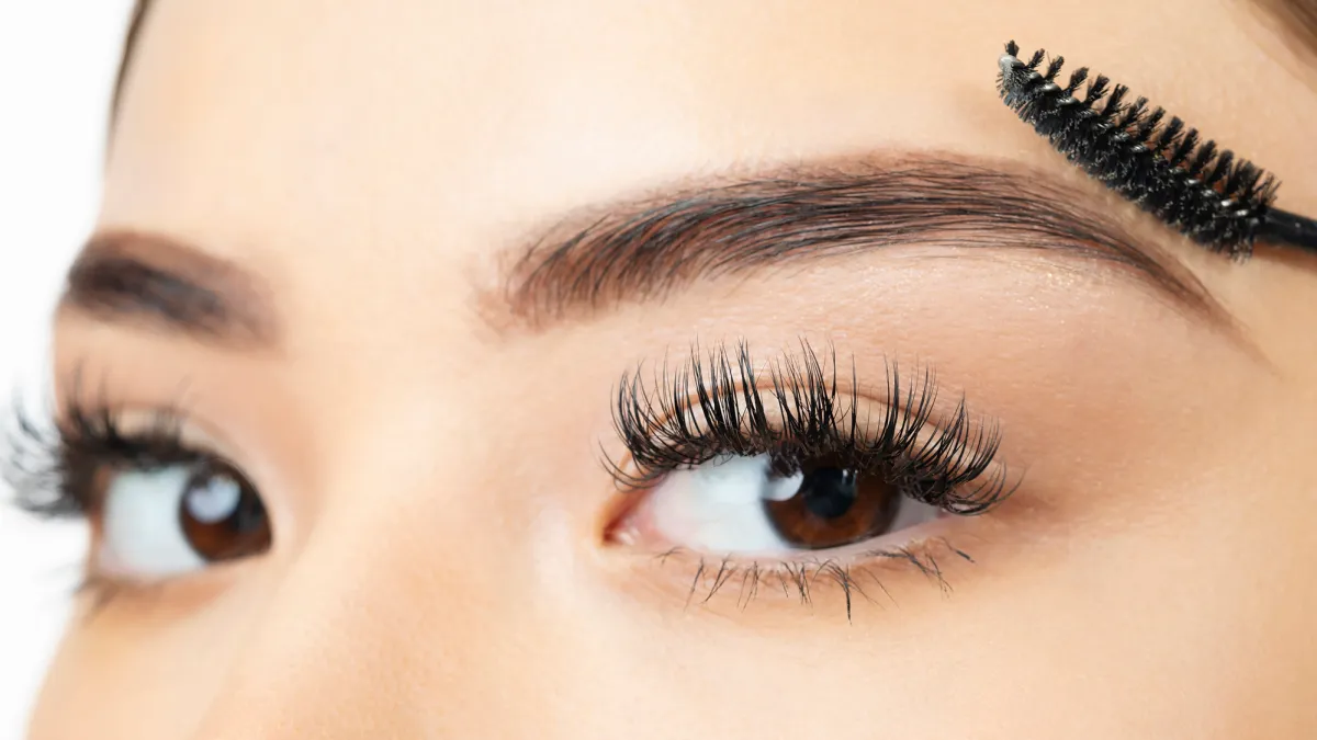 Young woman looking at the camera in the last step of brushing her eyebrow