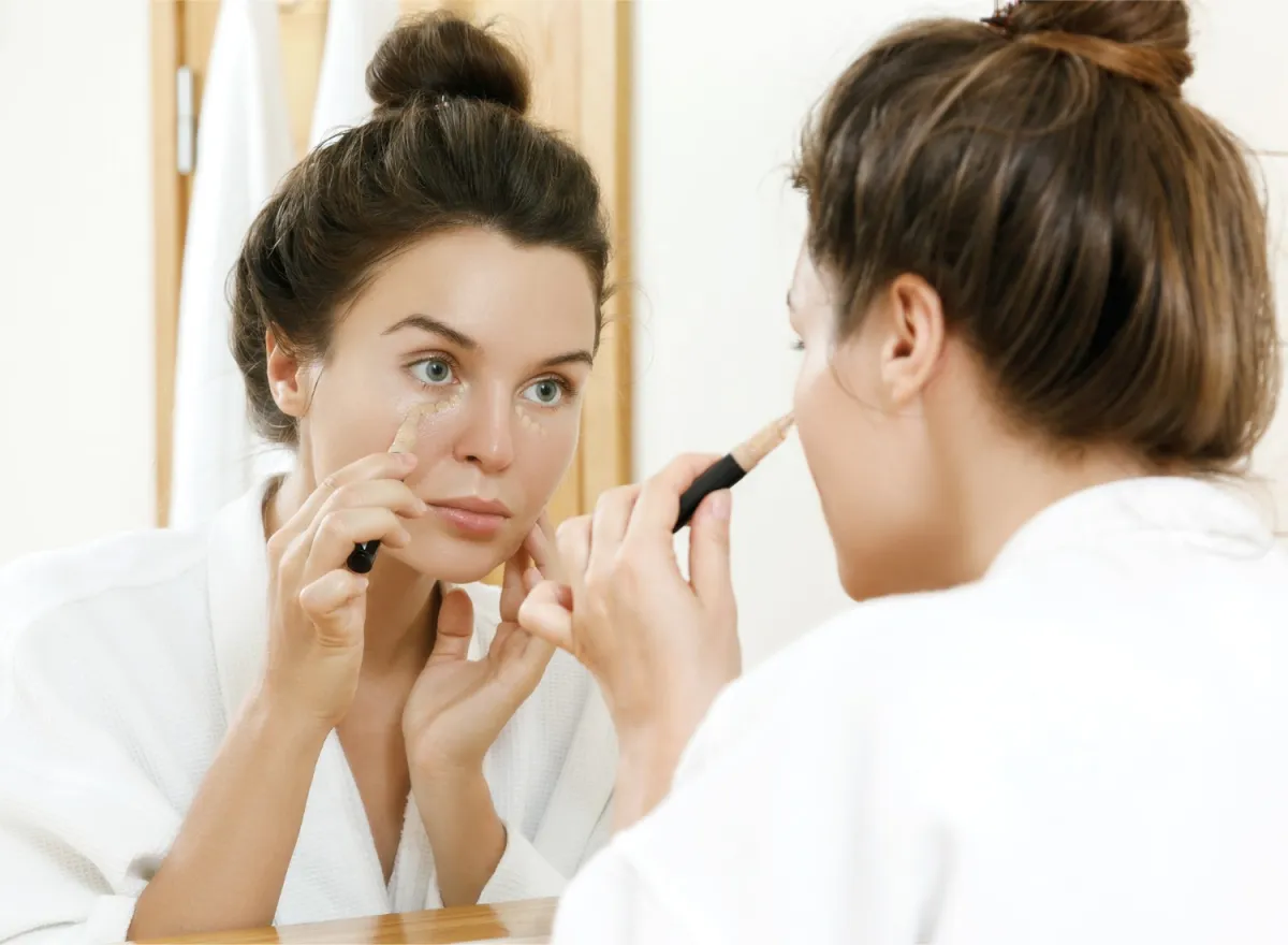 Woman applying under eye concealer