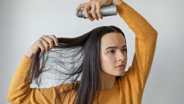 Woman applying hair spray