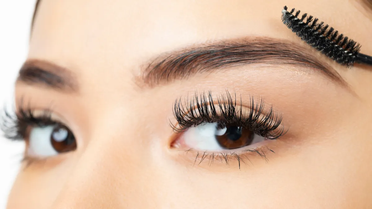 Young woman looking at the camera in the last step of brushing her eyebrow