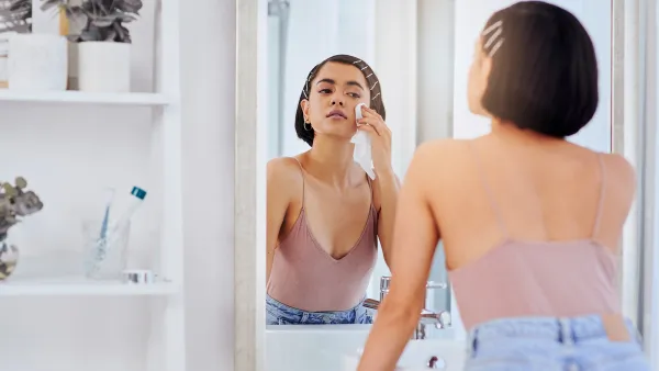 Shot of an attractive young woman cleansing her face with a wipe in front of the bathroom mirror