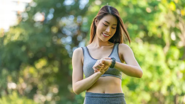 Portrait of a Young Woman in Sportswear and Smartwatch Enjoying Healthy Living and Exercise, Radiating Happiness and Positivity During Leisure Exercise in a Public Park at Sunset. Positive Vibes. Enjoying Healthy Living And Outdoor Wellbeing. Smart Wellness.
