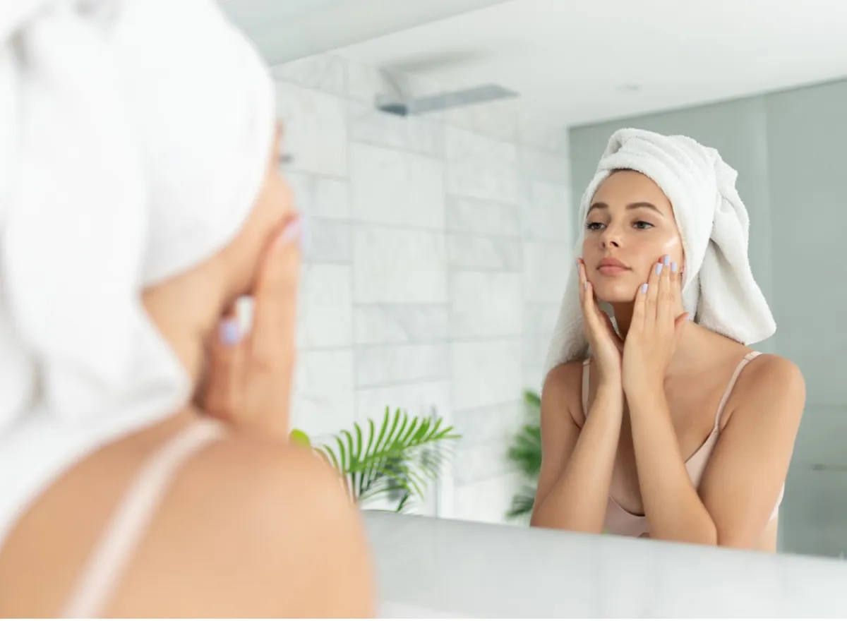 Woman looking at her skin in a mirror