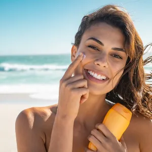 Woman applying sunscreen to her face