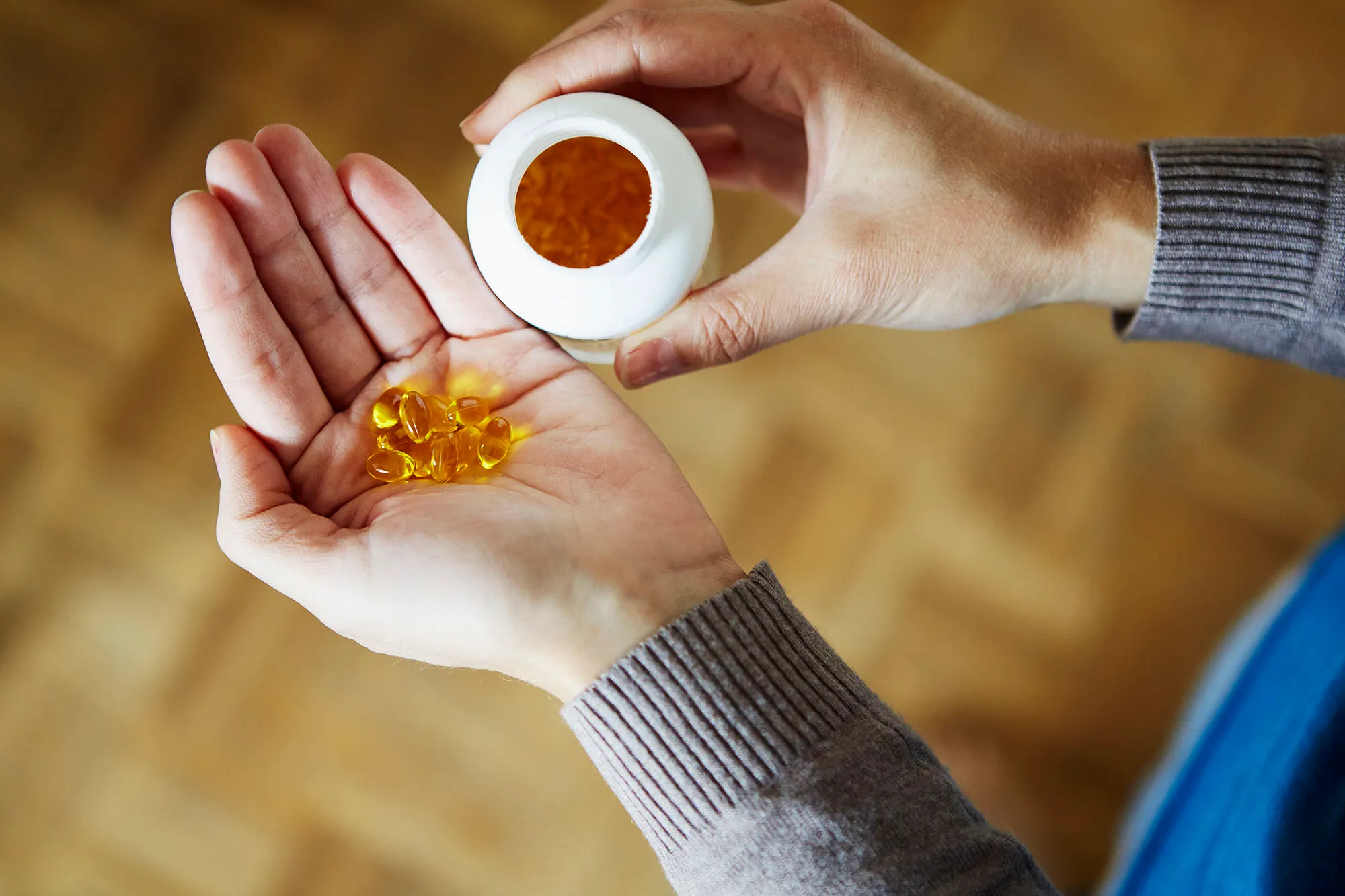 Young woman taking medication from bottle, close-up
