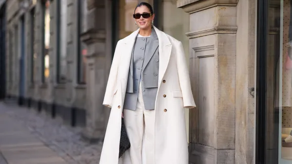 Inspiration shot: Darja Barannik wears sunglasses, golden earrings, a white oversized long coat, a gray oversized blazer jacket , white flared suit pants , pointed shoes, a black woven leather Bottega Veneta bag, outside Mark Kenly Domino Tan, during the Copenhagen Fashion Week AW24 on February 01, 2024 in Copenhagen, Denmark. (Photo by Edward Berthelot/Getty Images)