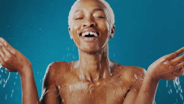 Cropped shot of a beautiful young woman splashing water over her face
