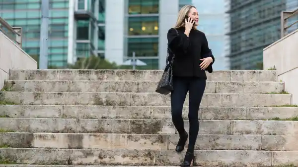 Beautiful young woman in real life using smartphone on the street