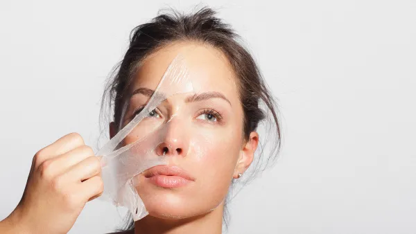 Close-up beauty portrait of a beautiful, natural young woman removing face mask.