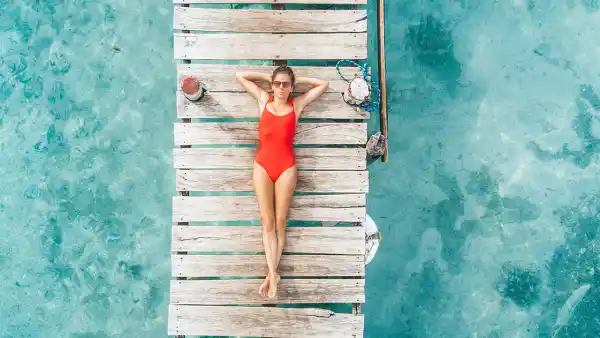 Aerial shot of woman relaxing in a water bungalow