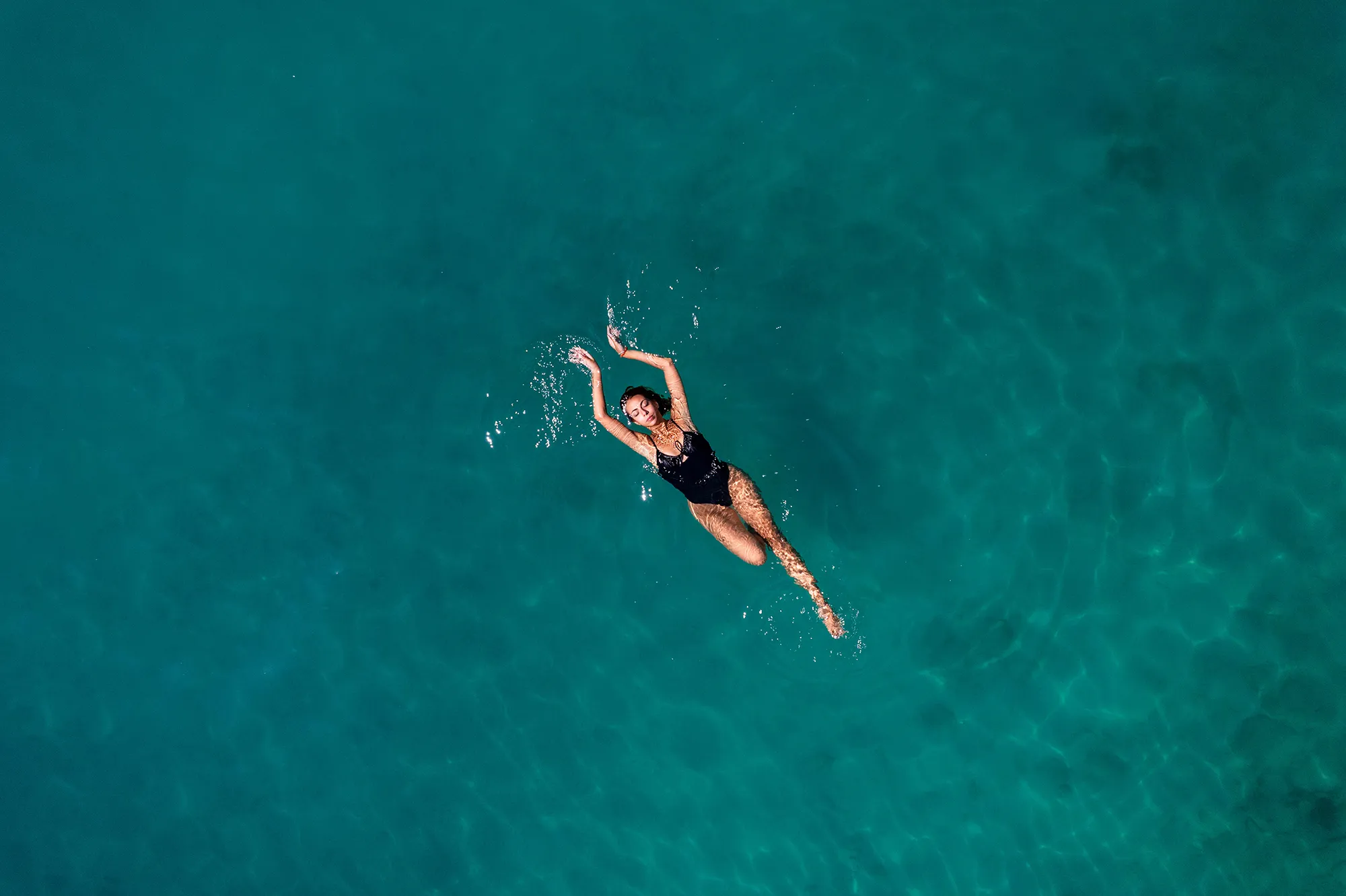 Aerial View Young Woman is Floating on Navy Blue Sea