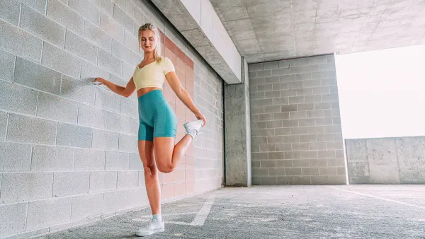 Beautiful Young Blond Woman in Trendy Form-Fitting, Pastel-Colored Active Wear or Jogger Clothing Preparing for a Workout