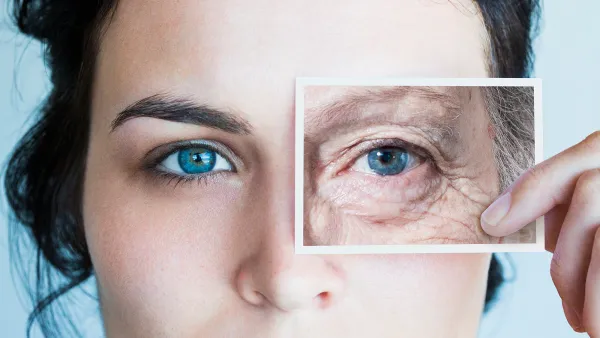 Young woman with photo of aged eye over her own