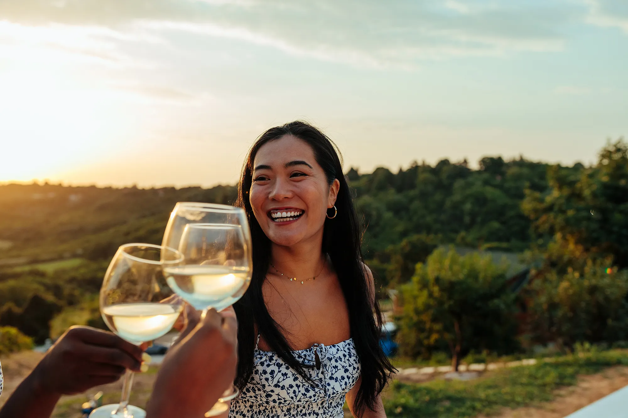 Happy woman having fun while toasting with wine at vineyard party