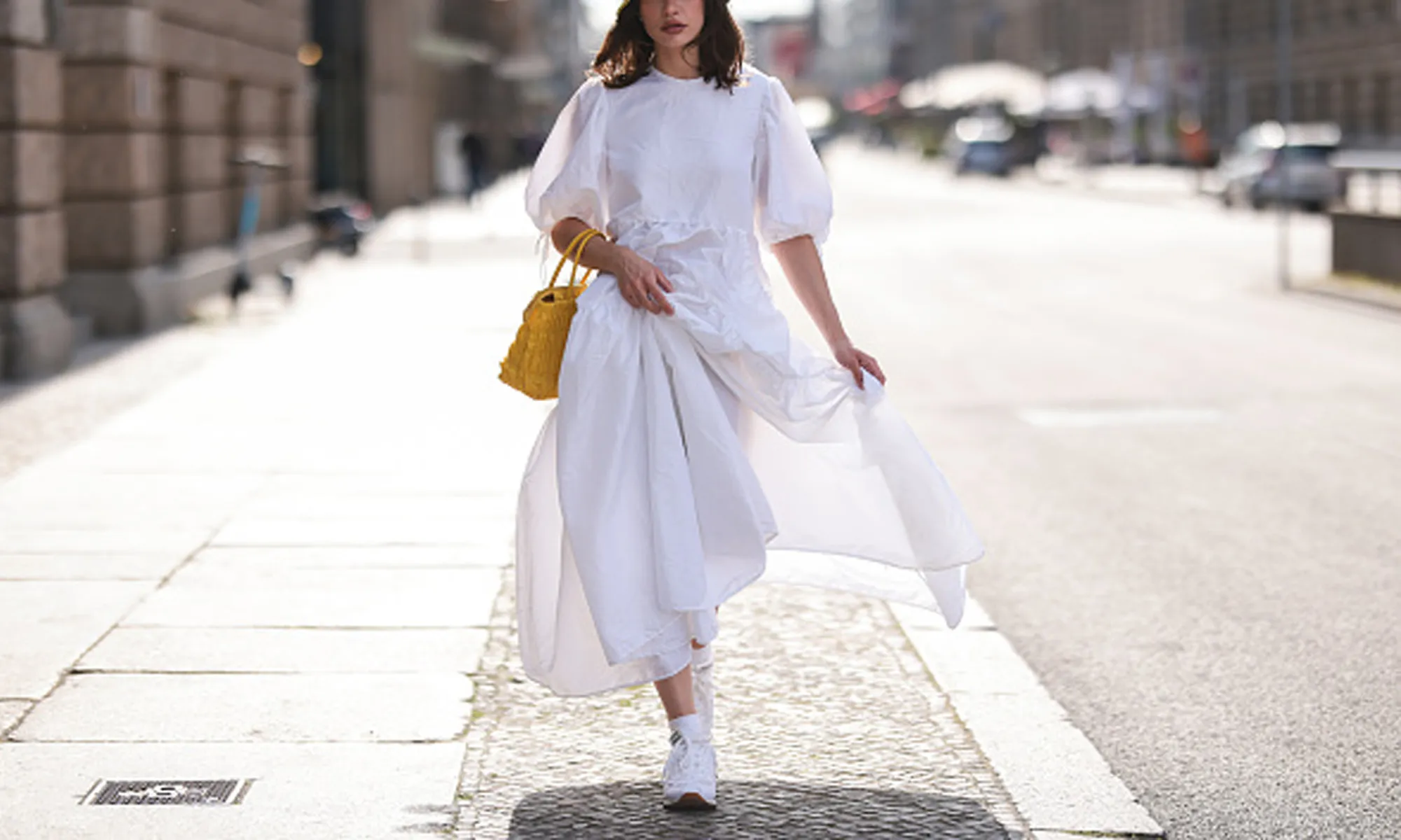 Woman wearing white dress and sneakers