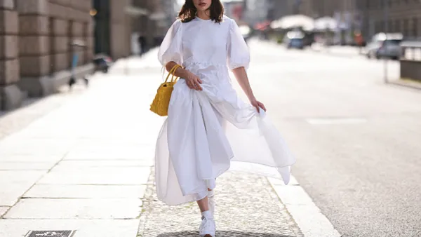 Woman wearing white dress and sneakers