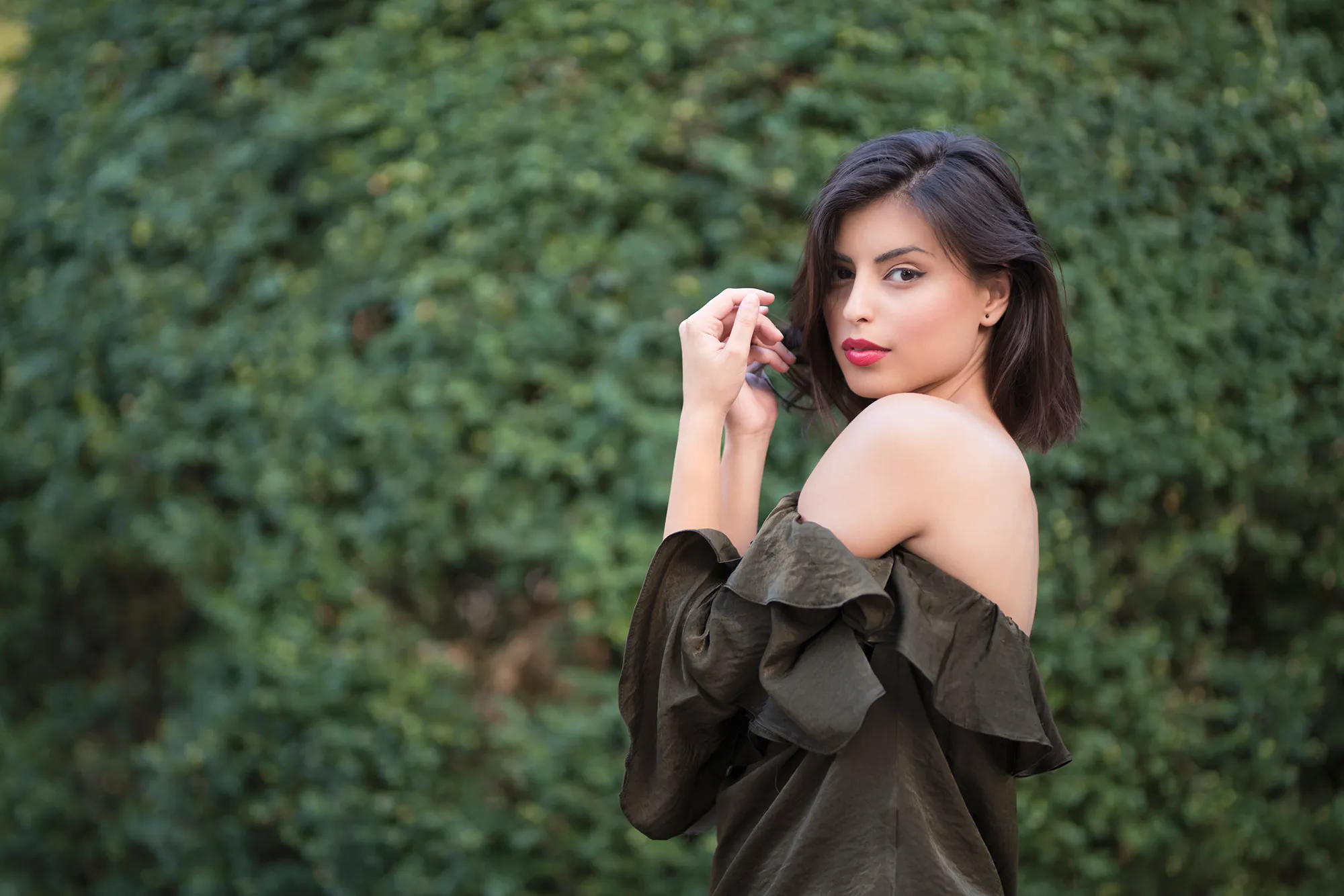 Fashion portrait of a beautiful, young woman wearing off - shoulder shirt.