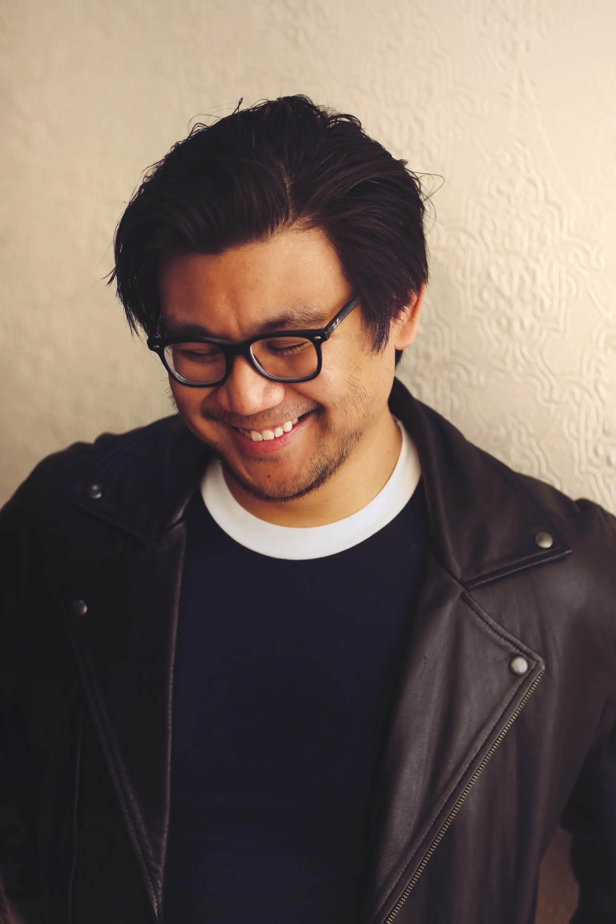 executive editor Tercius Bufete standing in front of a wall wearing a leather jacket