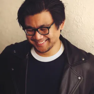 executive editor Tercius Bufete standing in front of a wall wearing a leather jacket