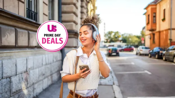 Happy smiling woman enjoying while listening to music in the city