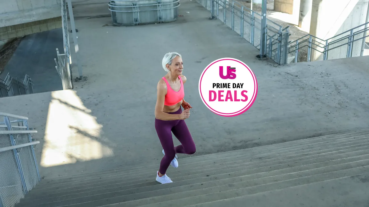 Senior woman with grey hair in sports clothes exercising outside while listening to music. Beautiful mature woman jogging.