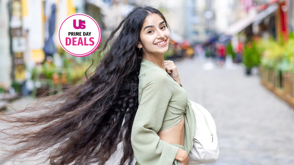 Indian student charms with a radiant smile as she enjoys urban exploration and sightseeing on a sunny day in the city.