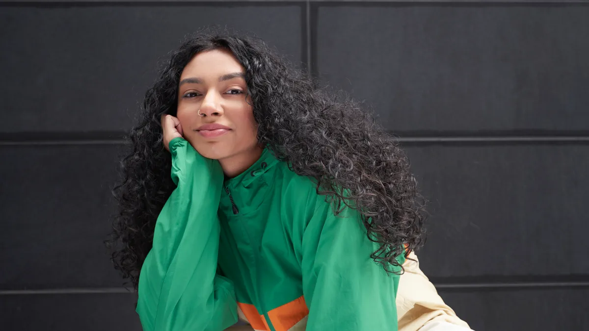 Portrait of young woman against black background