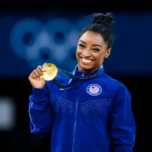 PARIS, FRANCE - AUGUST 3: Gold mealist Simone Biles of Team United States celebrates on the podium during the medal ceremony for the Artistic Gymnastics Women's Vault Final on day eight of the Olympic Games Paris 2024 at the Bercy Arena on August 3, 2024 in Paris, France. (Photo by Tom Weller/VOIGT/GettyImages)