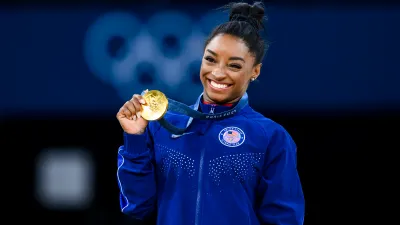 PARIS, FRANCE - AUGUST 3: Gold mealist Simone Biles of Team United States celebrates on the podium during the medal ceremony for the Artistic Gymnastics Women's Vault Final on day eight of the Olympic Games Paris 2024 at the Bercy Arena on August 3, 2024 in Paris, France. (Photo by Tom Weller/VOIGT/GettyImages)