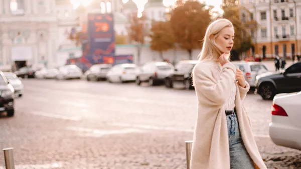 Young thoughtful woman walking on street in city
