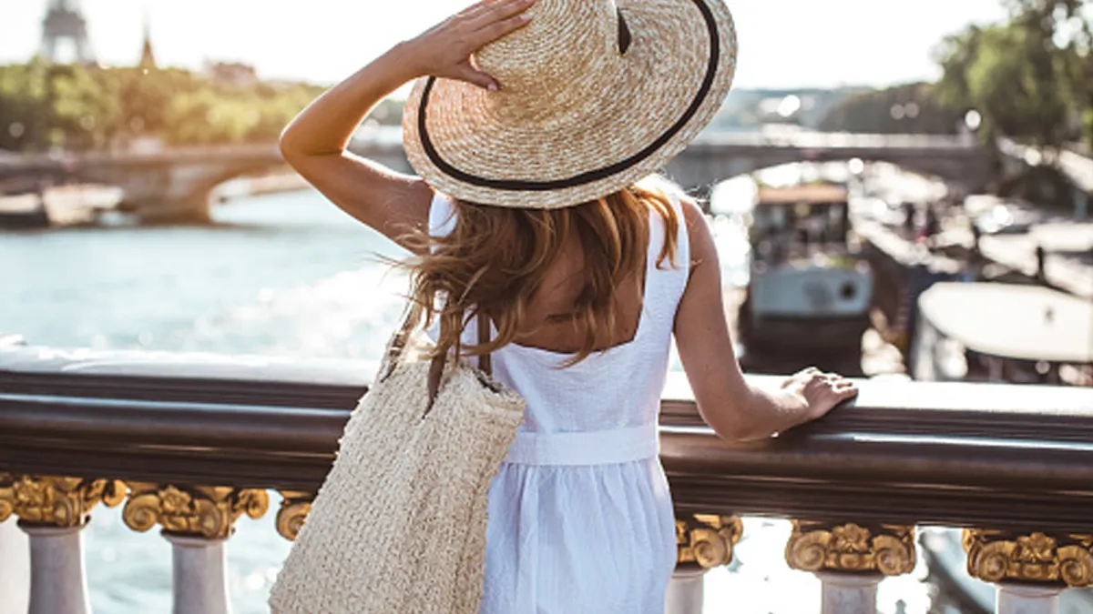 woman wearing white dress, hat and bag in Paris