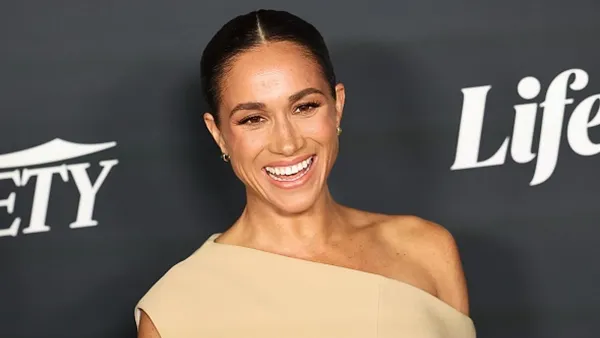 Meghan Markle wearing tan dress on red carpet