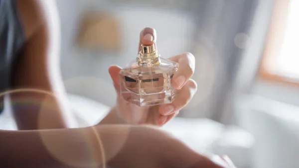 Woman spraying perfume on wrist