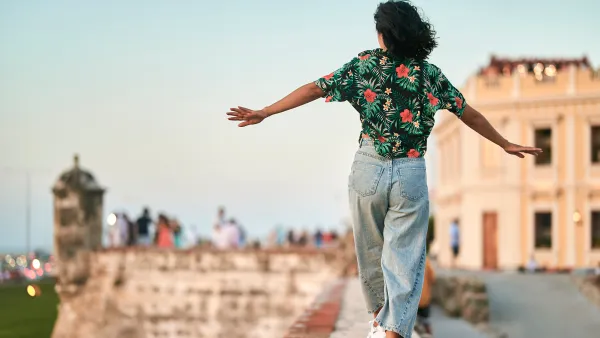 Woman walking on wall seen from behind in Cartagena, Colombia