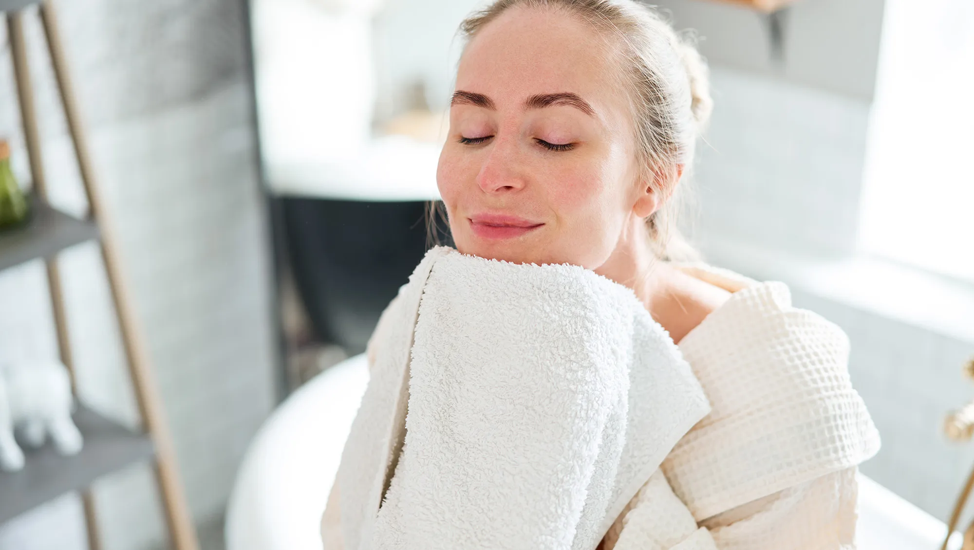 Woman wiping face in bathroom