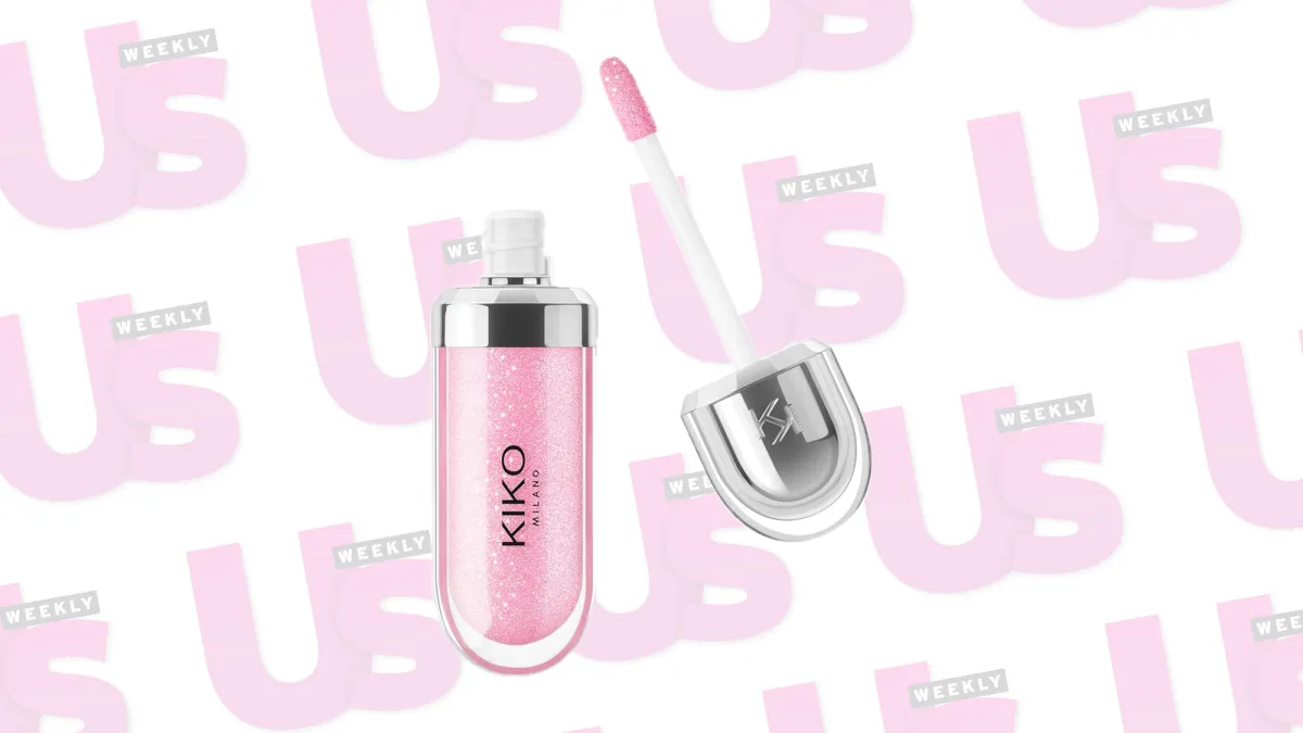 A pink lip gloss in front of a UsWeekly background.