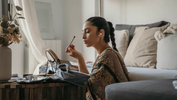 a woman applying makeup in the bedroom