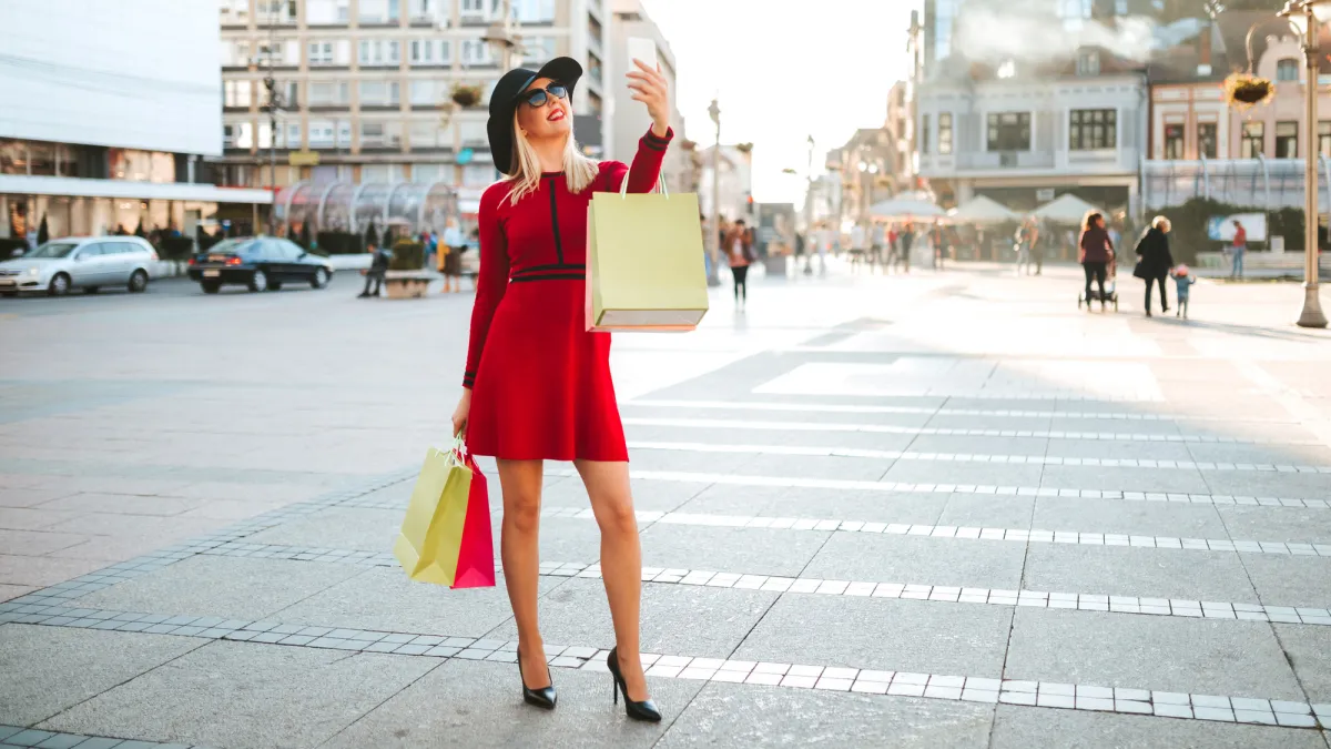 woman in a red dress taking a selfie on the street