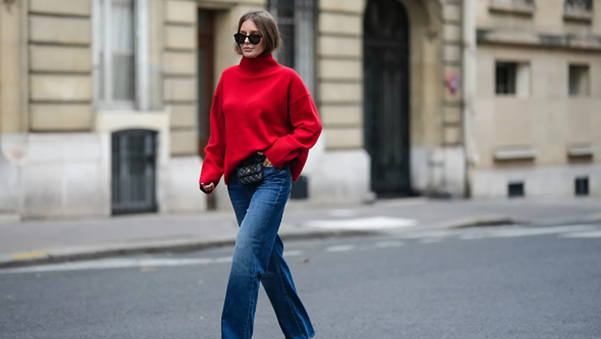 woman wearing loose red sweater and blue jeans