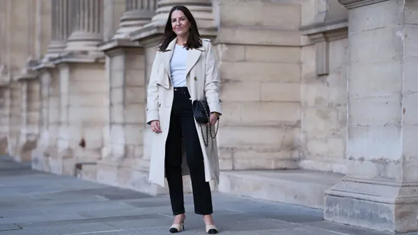 woman wearing white trench coat and black pants