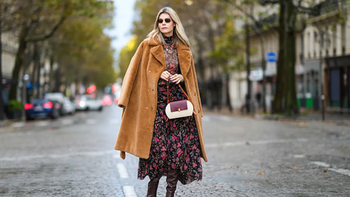 woman wearing floral fall dress and tan coat