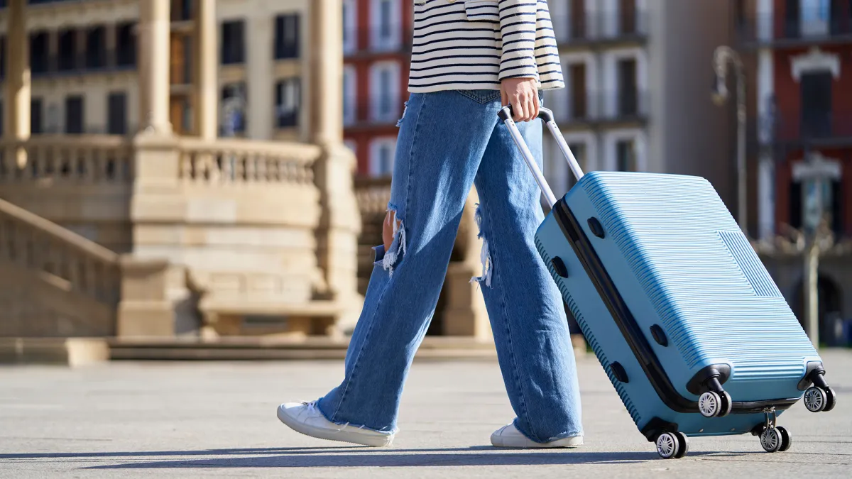 Close-up of a woman with a trolley on the street on the way to the hotel