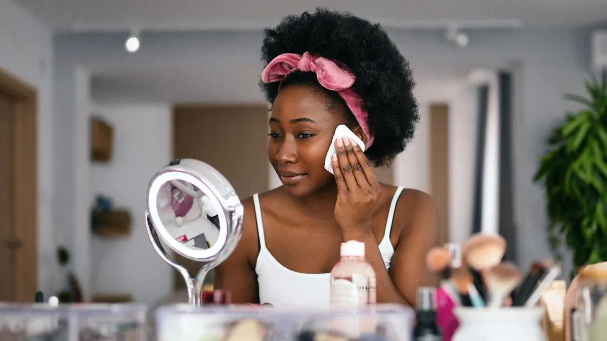 Beautiful woman cleaning her face with a face cloth.