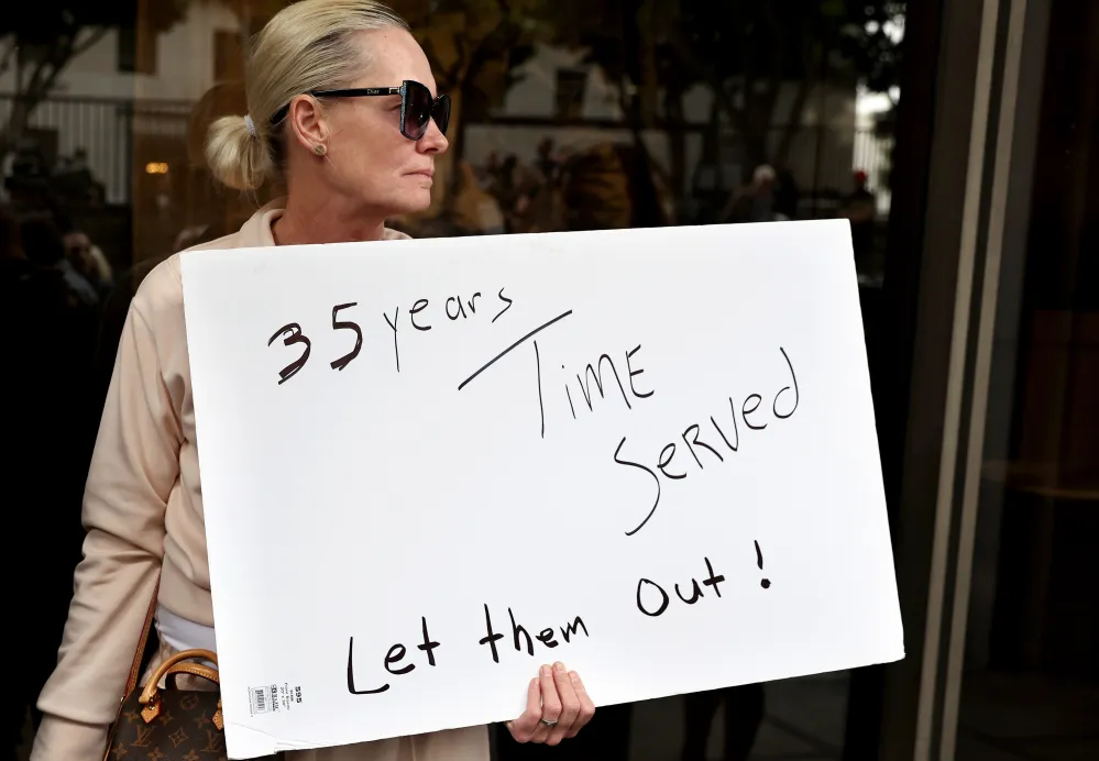 LOS ANGELES, CALIFORNIA - OCTOBER 16: A supporter holds a sign at a press conference with Menendez family members outside the Criminal Courts Building on October 16, 2024 in Los Angeles, California. Members of the Menendez family held the news conference to call for the release of brothers Lyle and Erik Menendez from prison nearly thirty years after their conviction in 1996 for killing their parents in Beverly Hills. The district attorney&rsquo;s office is looking at new evidence which supports the brothers&rsquo; claim they were sexually abused by their father.
