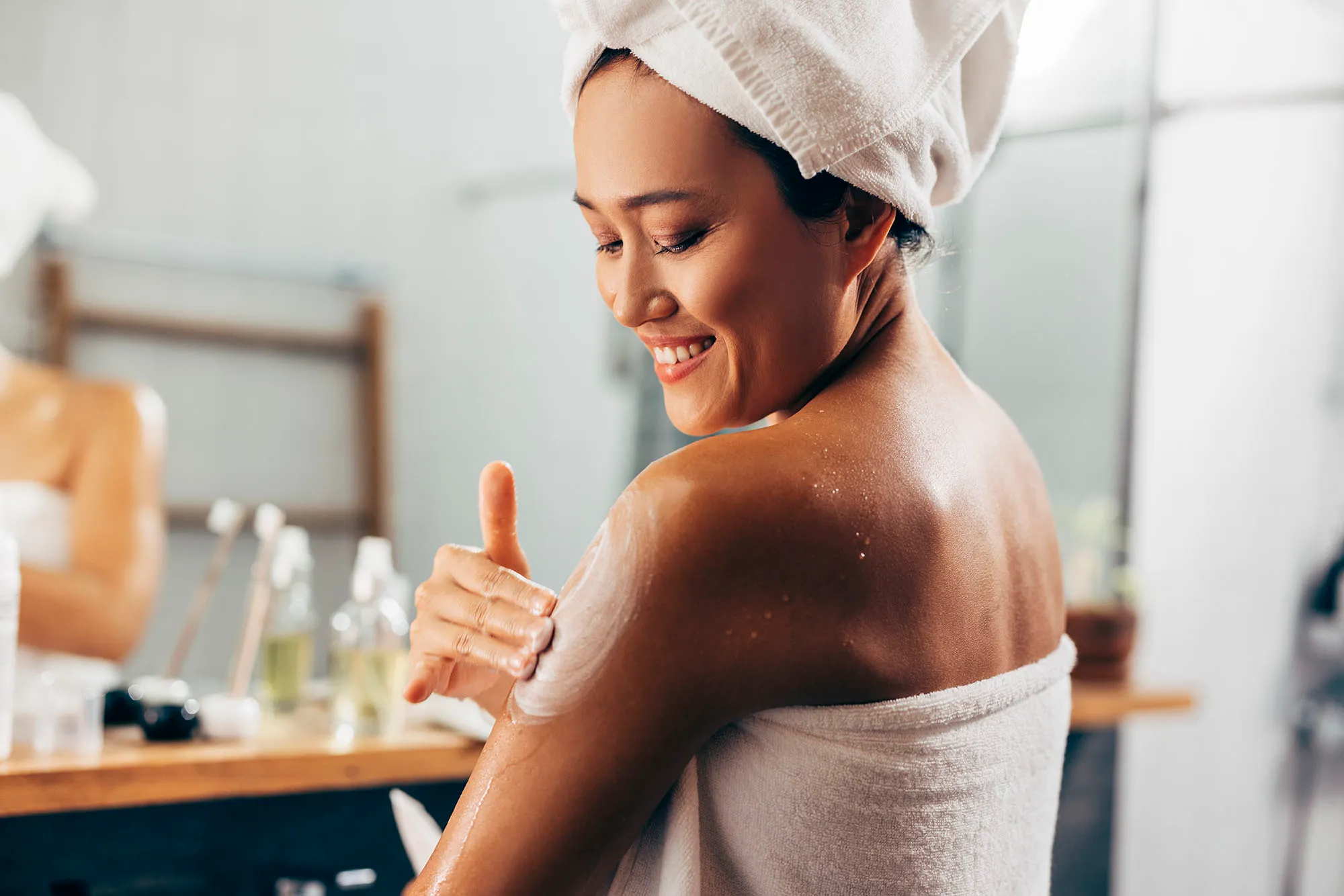 Woman Putting On Cream After A Shower
