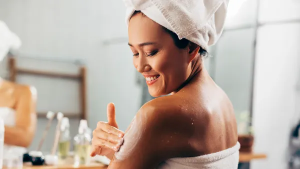 Woman Putting On Cream After A Shower